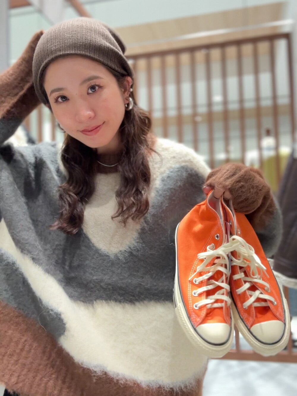 グレー系のニット/セーター、ブラック系のワンピース、ブルー系のデニムパンツを着用したレディースの秋コーディネートの10枚目の写真