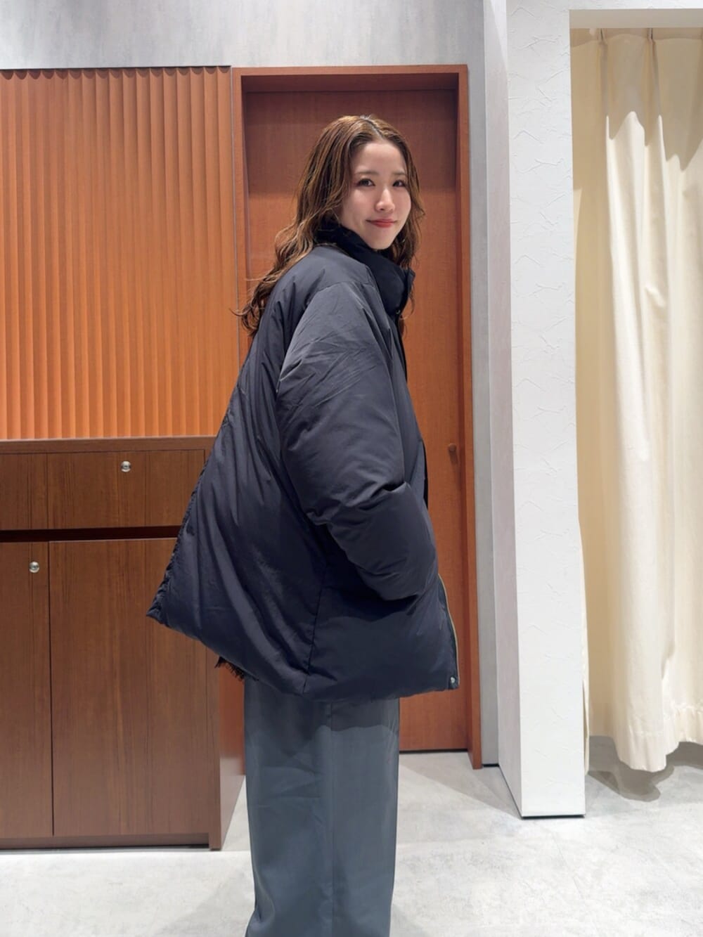 ブラック系のダウンジャケット/コート、グレー系のその他パンツ、ブラック系のキャミソールを着用したレディースの冬コーディネートの7枚目の写真