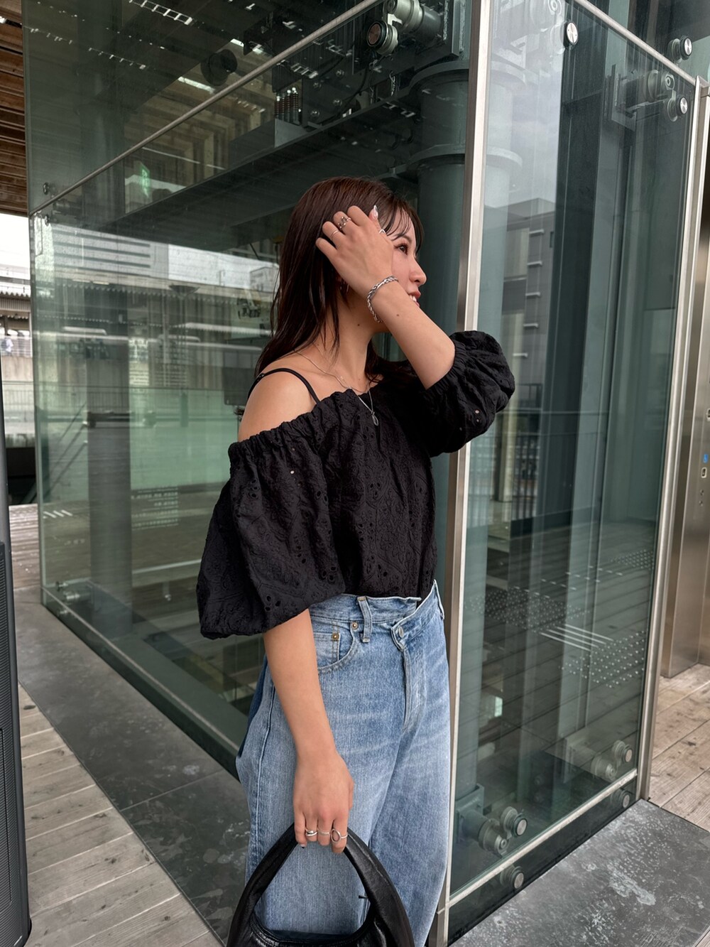 ブルー系のデニムパンツ、ブラック系のシャツ/ブラウス、ブラック系のハンドバッグを着用したレディースの春コーディネートの8枚目の写真