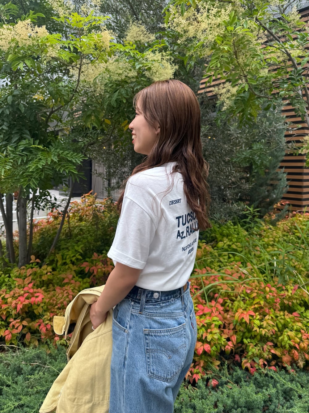 ブルー系のデニムパンツ、イエロー系のブルゾン、ホワイト系のTシャツ/カットソーを着用したレディースの夏コーディネートの8枚目の写真