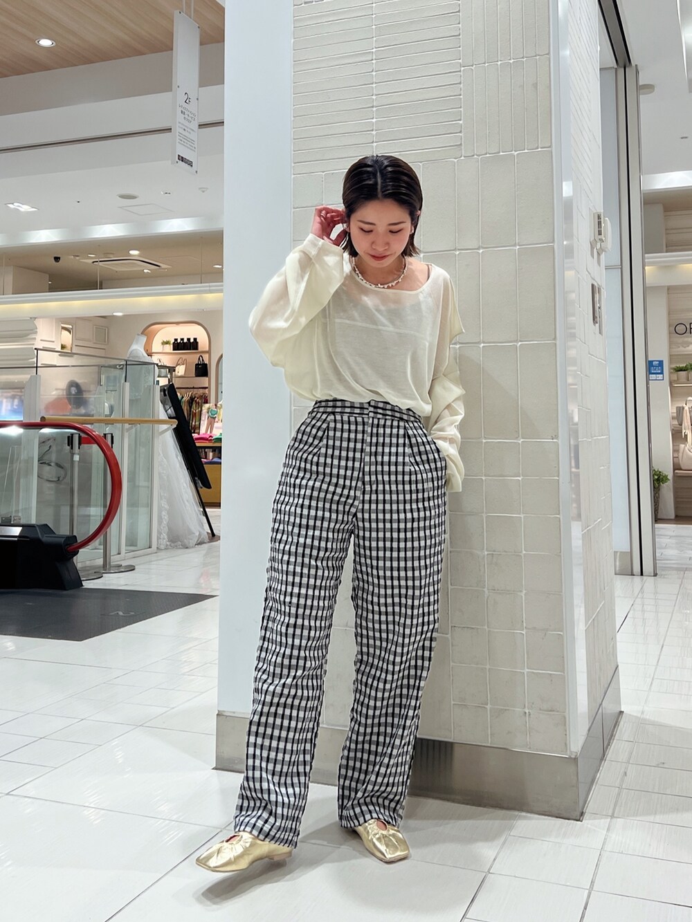 イエロー系のニット/セーター、イエロー系のパンプス、グレー系のその他パンツを着用したレディースの冬コーディネートの8枚目の写真