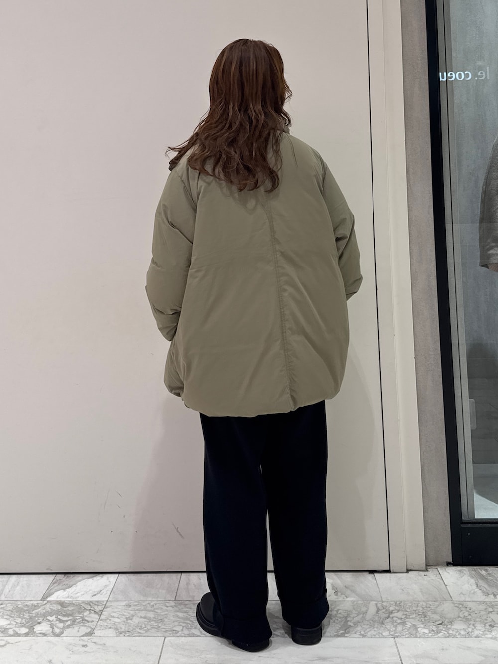 ブラック系のニット/セーター、ホワイト系のTシャツ/カットソー、ブラック系のその他パンツを着用したレディースの冬コーディネートの4枚目の写真