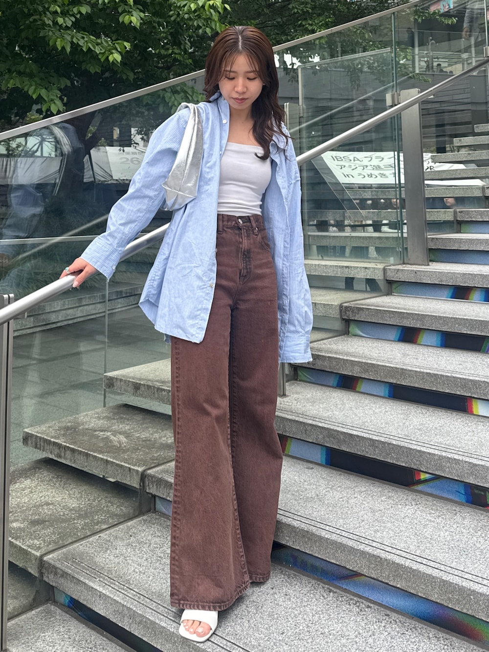 ブラウン系のデニムパンツ、ブルー系のシャツ/ブラウスを着用したレディースの春コーディネートの2枚目の写真