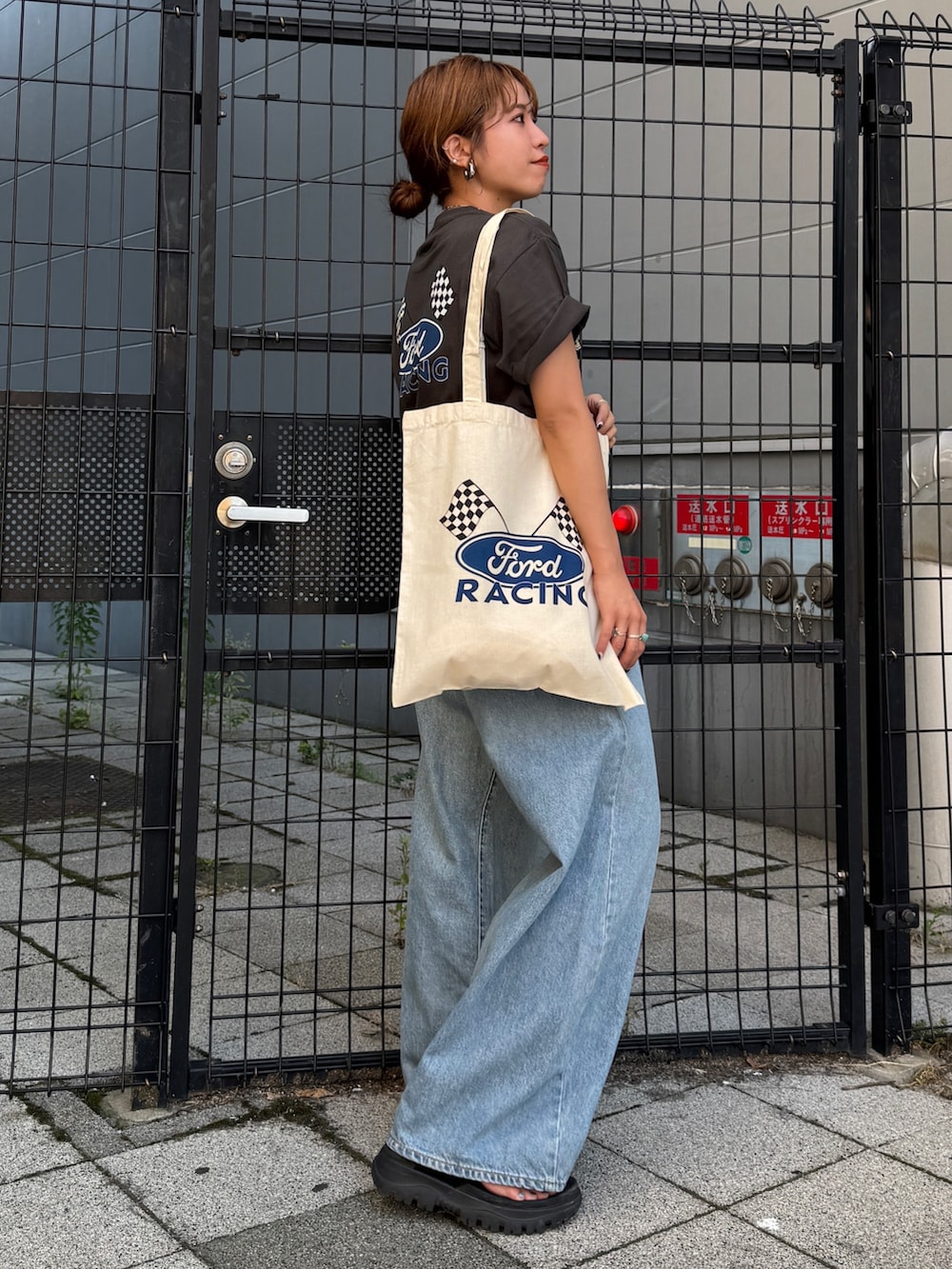 ブルー系のデニムパンツ、グレー系のTシャツ/カットソー、ホワイト系のトートバッグを着用したレディースの夏コーディネートの4枚目の写真