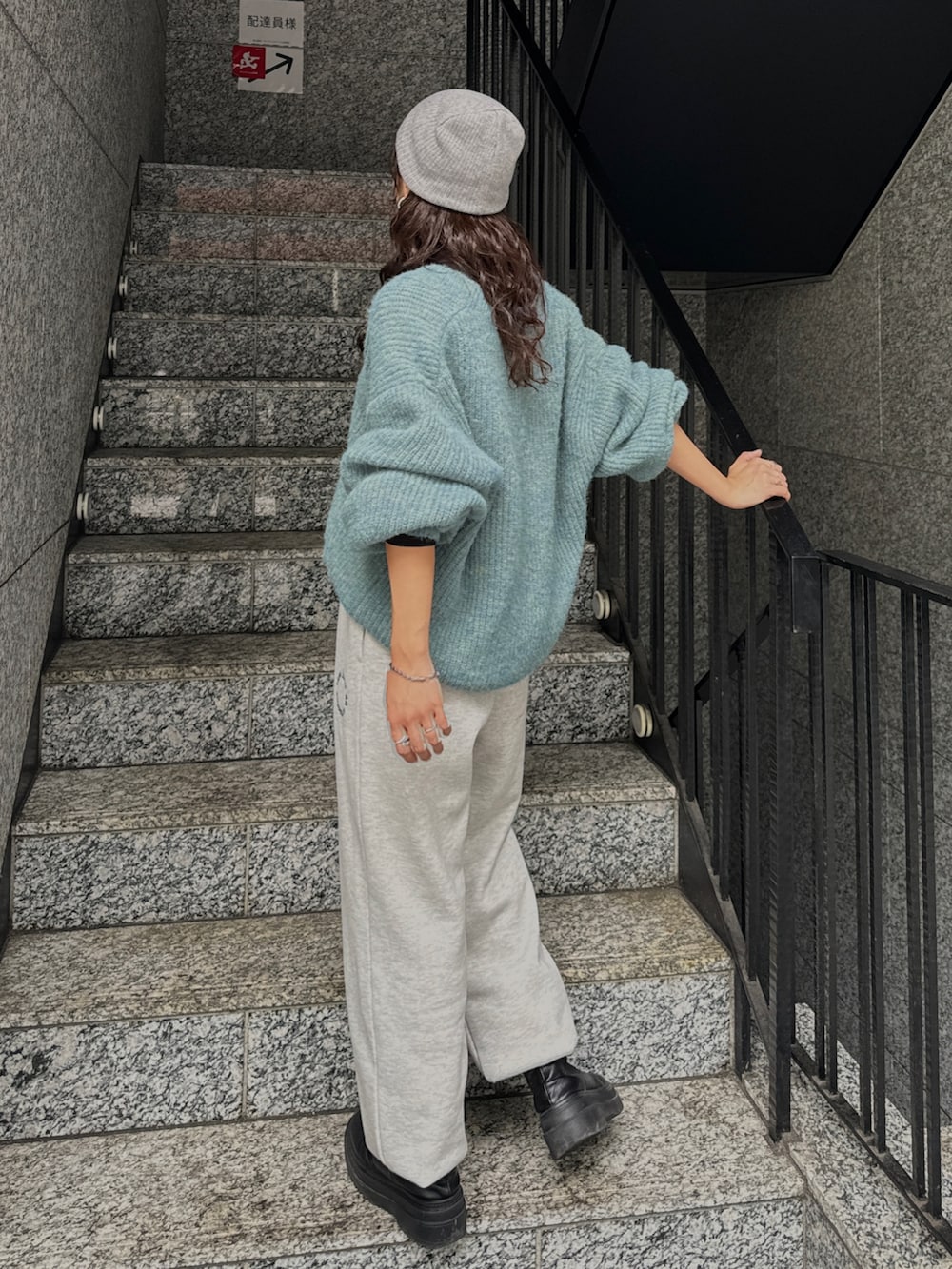 ブラック系のTシャツ/カットソー、グレー系のスウェットパンツ、ブルー系のニット/セーターを着用したレディースの秋コーディネートの7枚目の写真