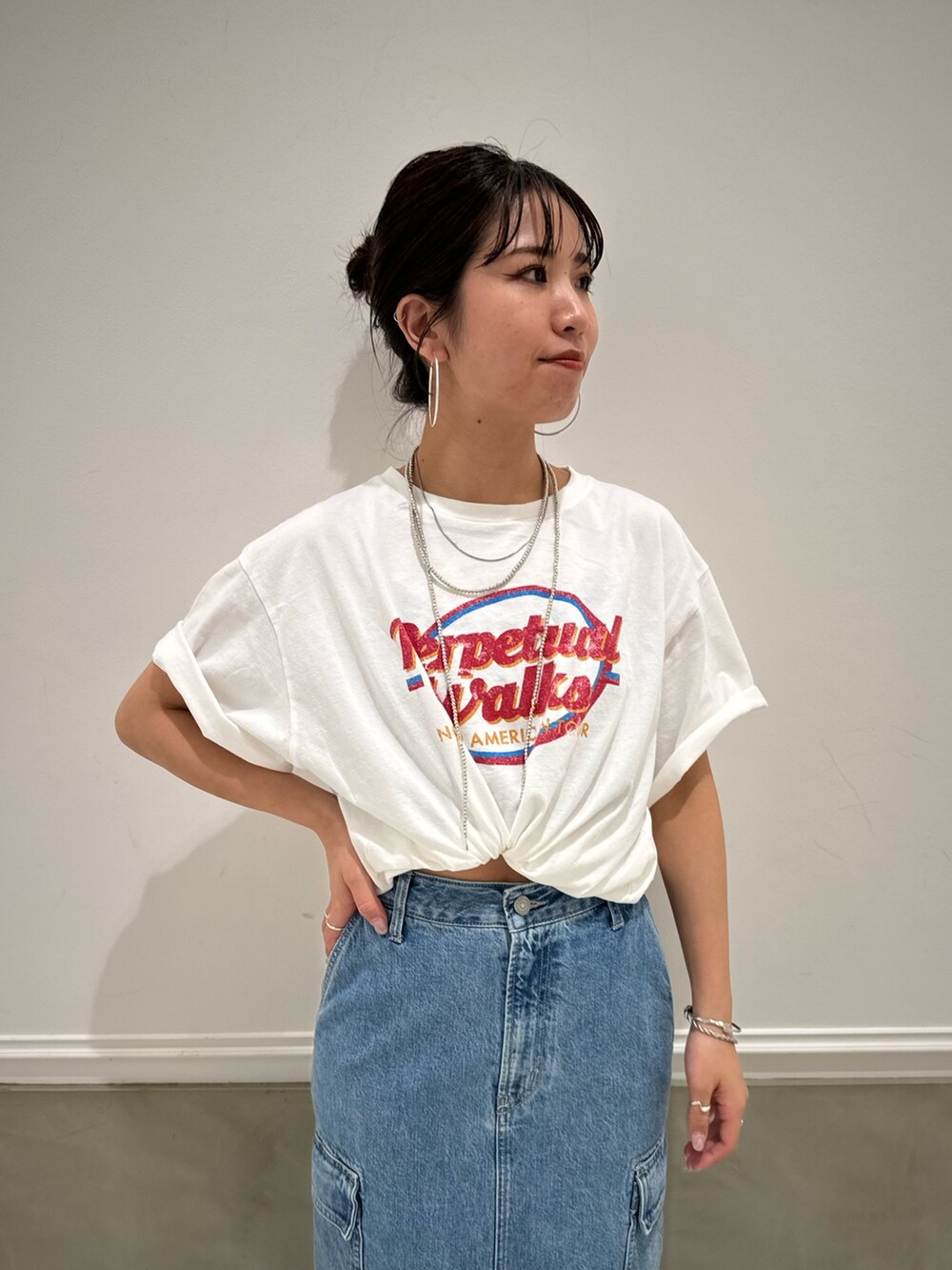 ブルー系のデニムスカート、ホワイト系のTシャツ/カットソー、ブルー系のスニーカーを着用したレディースの春コーディネートの7枚目の写真