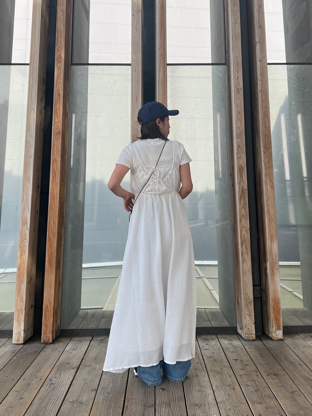 ホワイト系のTシャツ/カットソー、ホワイト系のワンピース、ブルー系のデニムパンツを着用したレディースの春コーディネートの5枚目の写真