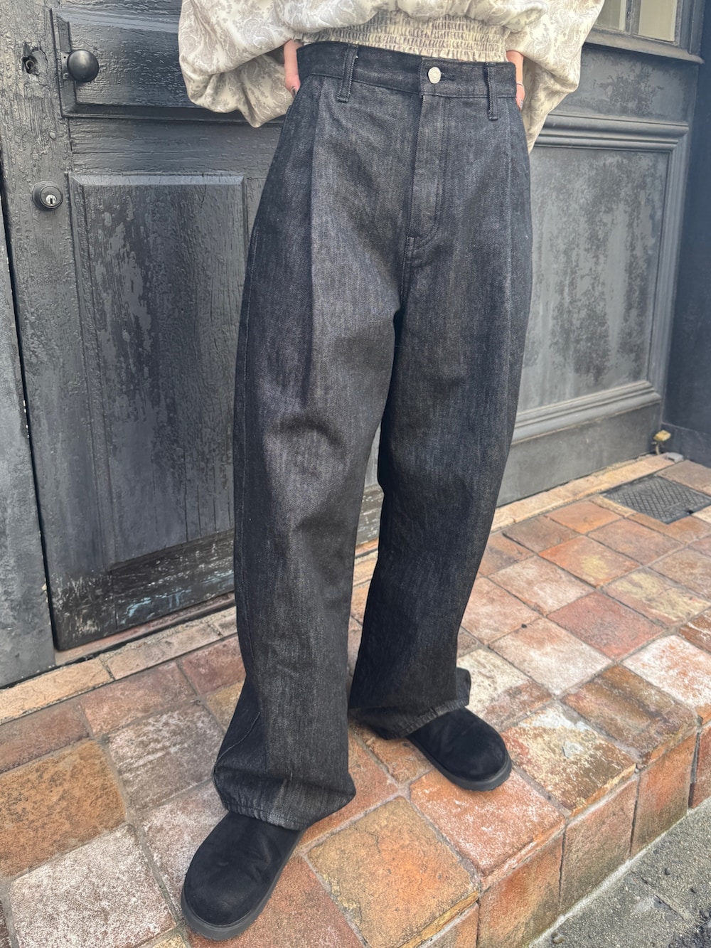 ブラック系のデニムパンツ、ブラック系のスリッポン、ホワイト系のシャツ/ブラウスを着用したレディースの秋コーディネートの6枚目の写真