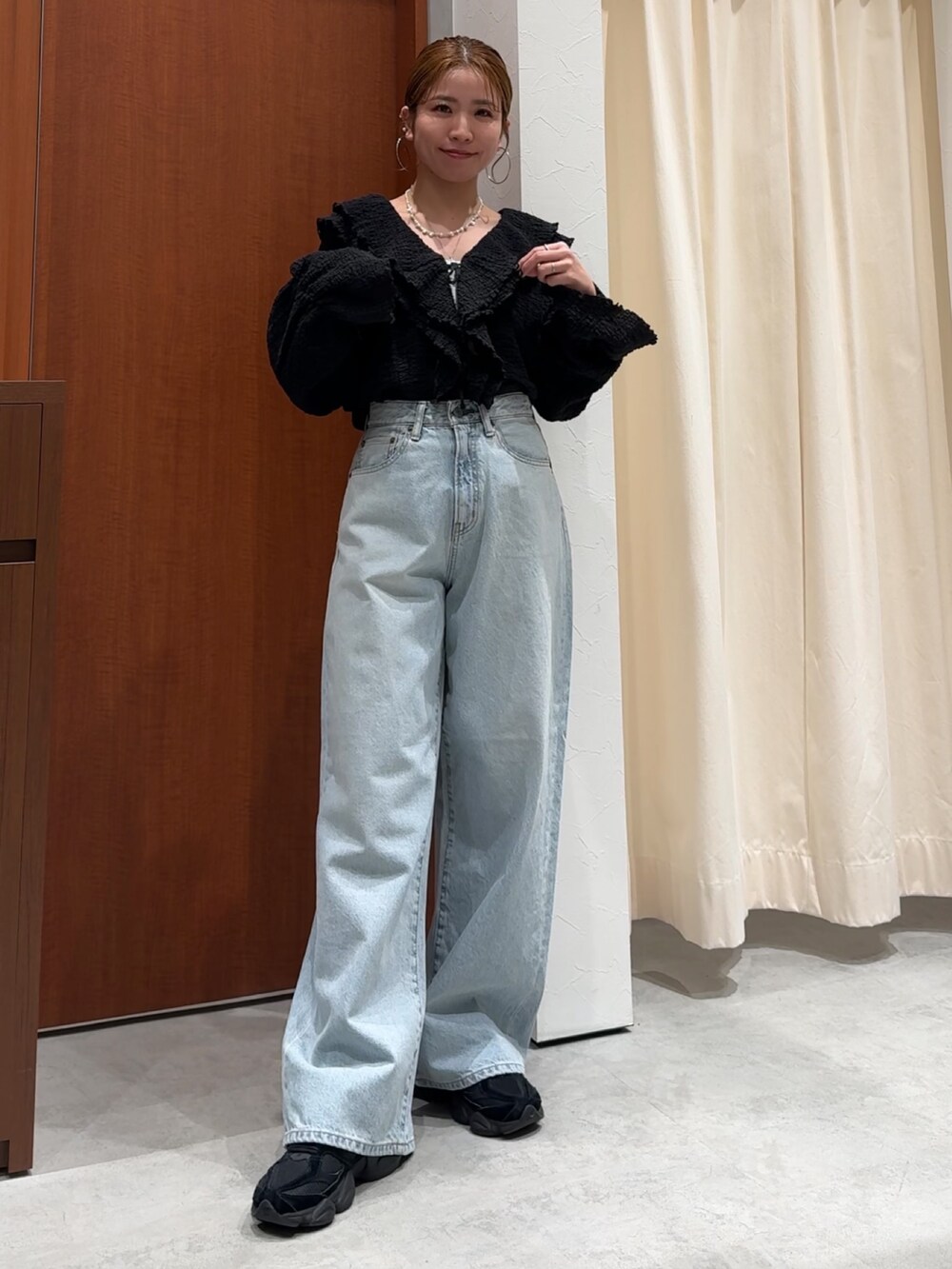 ブラック系のシャツ/ブラウス、ブルー系のデニムパンツを着用したレディースの春コーディネートの2枚目の写真