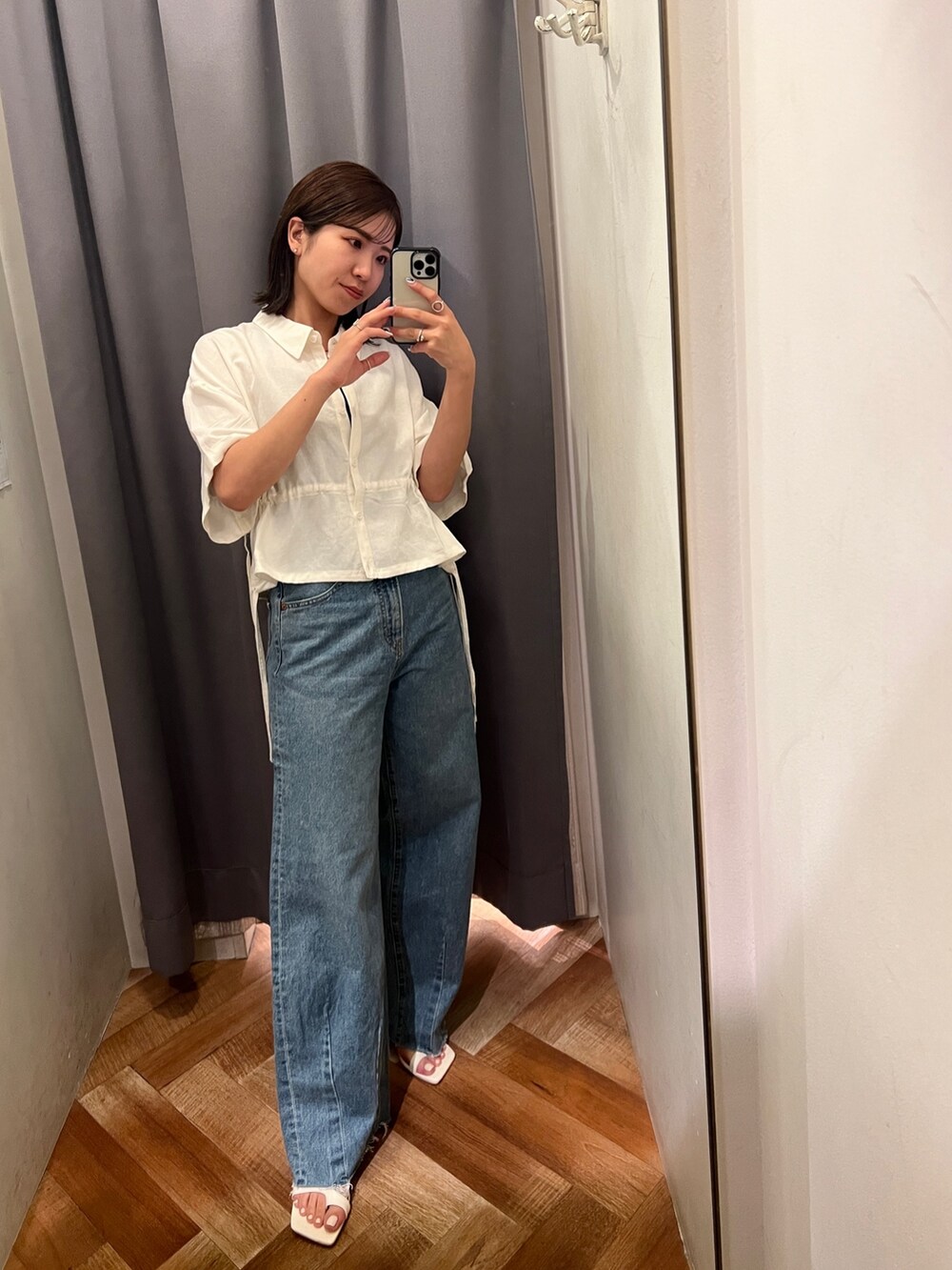 ブルー系のデニムパンツ、ホワイト系のサンダル、ホワイト系のシャツ/ブラウスを着用したレディースの春コーディネートの3枚目の写真