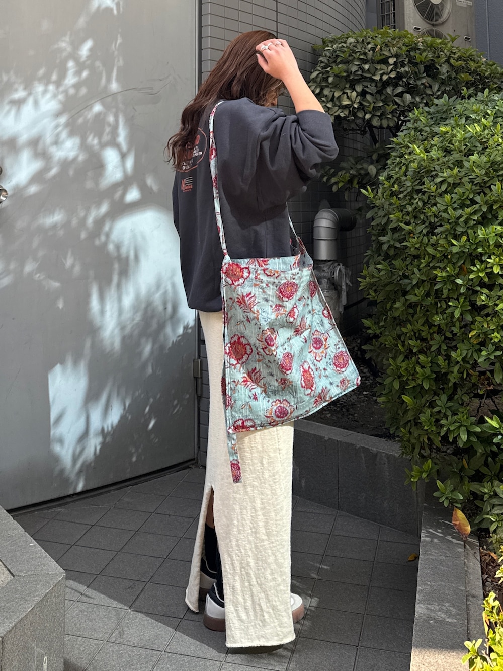 グリーン系のショルダーバッグ、グレー系のスウェット、ホワイト系のスカートを着用したレディースの冬コーディネートの4枚目の写真