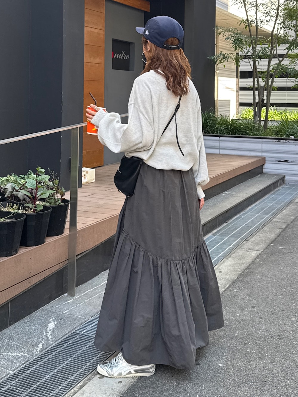 グレー系のスカート、ホワイト系のTシャツ/カットソー、ブルー系のキャップを着用したレディースの夏コーディネートの4枚目の写真