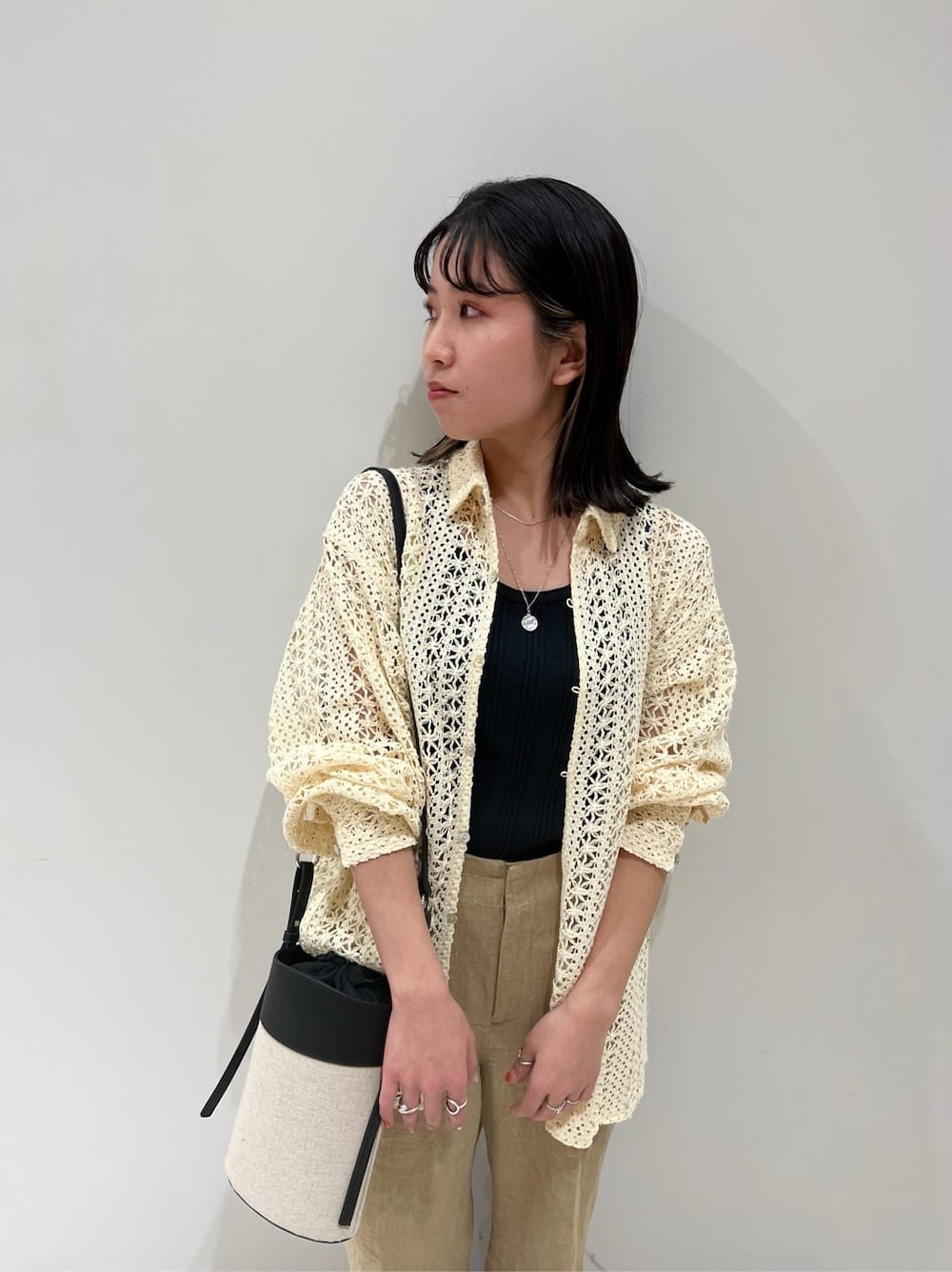 ブラック系のタンクトップ、ブラック系のサンダル、ブラック系のショルダーバッグを着用したレディースの春コーディネートの5枚目の写真