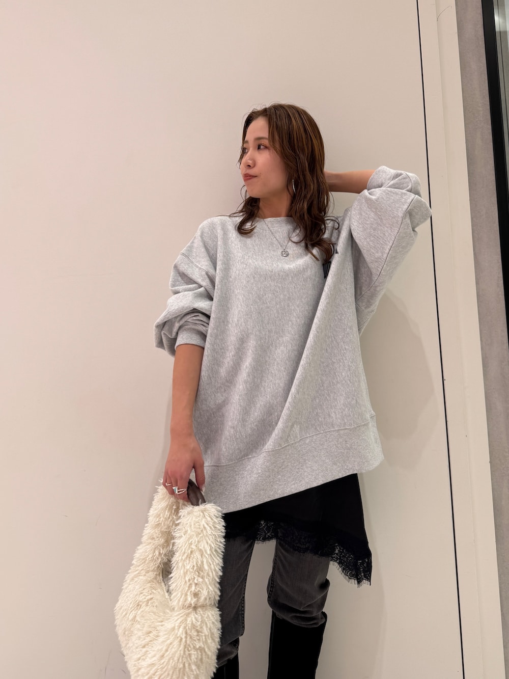 グレー系のスウェット、ブラック系のキャミソール、ブラック系のデニムパンツを着用したレディースの冬コーディネートの10枚目の写真