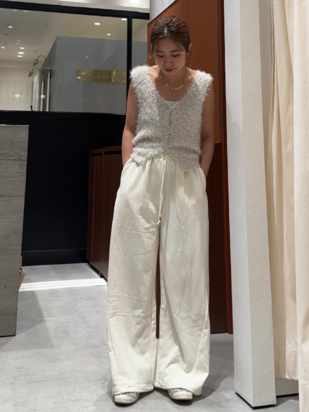 ホワイト系のスウェットパンツ、ホワイト系のベストを着用したレディースの春コーディネートの2枚目の写真