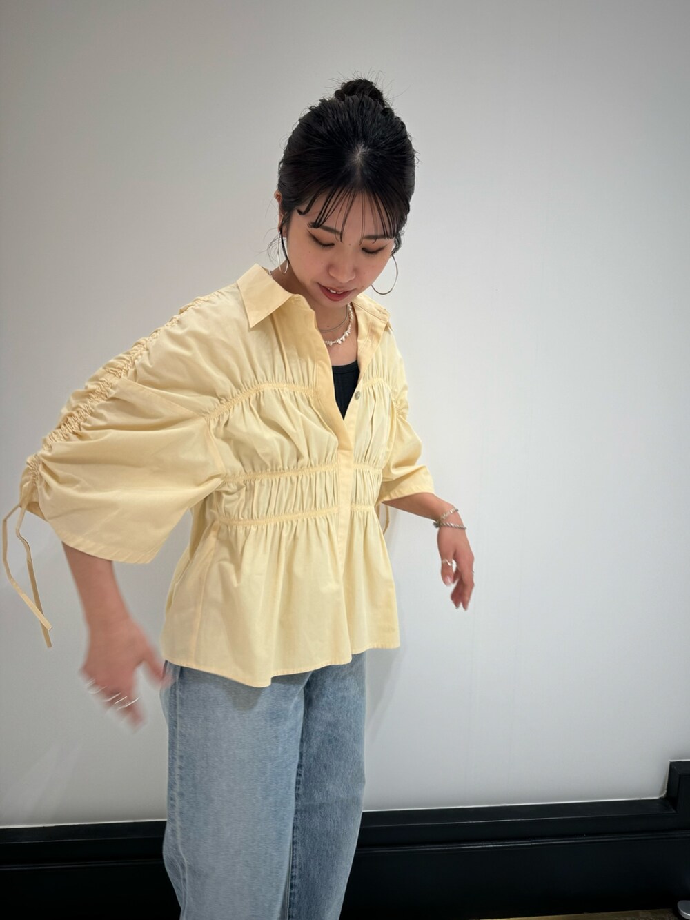 イエロー系のシャツ/ブラウス、ブルー系のデニムパンツ、グレー系のTシャツ/カットソーを着用したレディースの春コーディネートの6枚目の写真