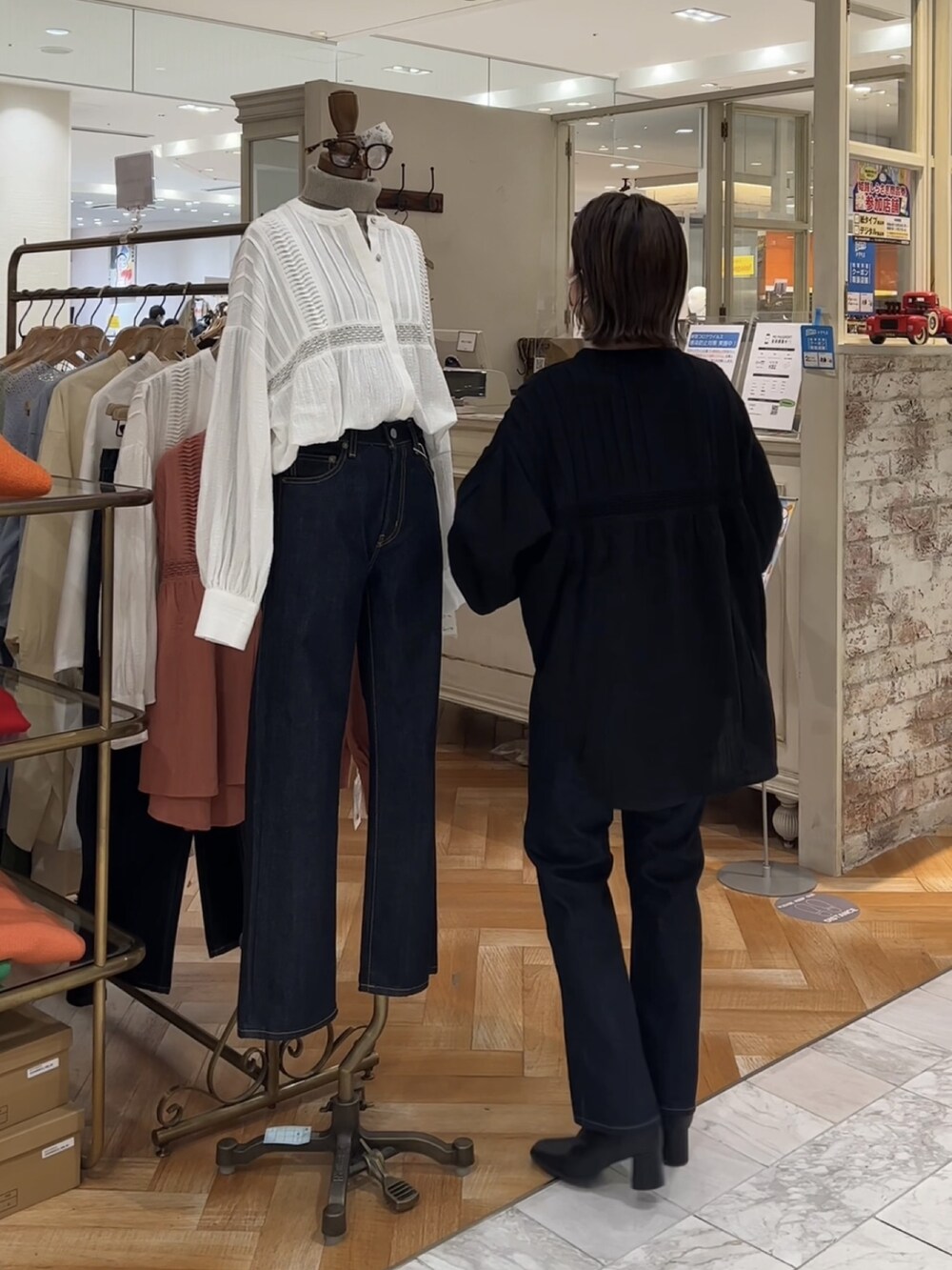 ブラック系のシャツ/ブラウス、ブルー系のデニムパンツを着用したレディースの冬コーディネートの2枚目の写真