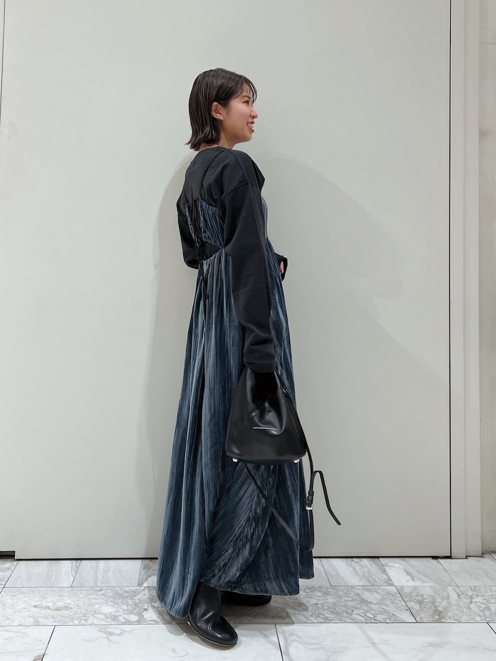 ブルー系のワンピース、ブラック系のTシャツ/カットソー、ブラック系のブーツを着用したレディースの冬コーディネートの4枚目の写真