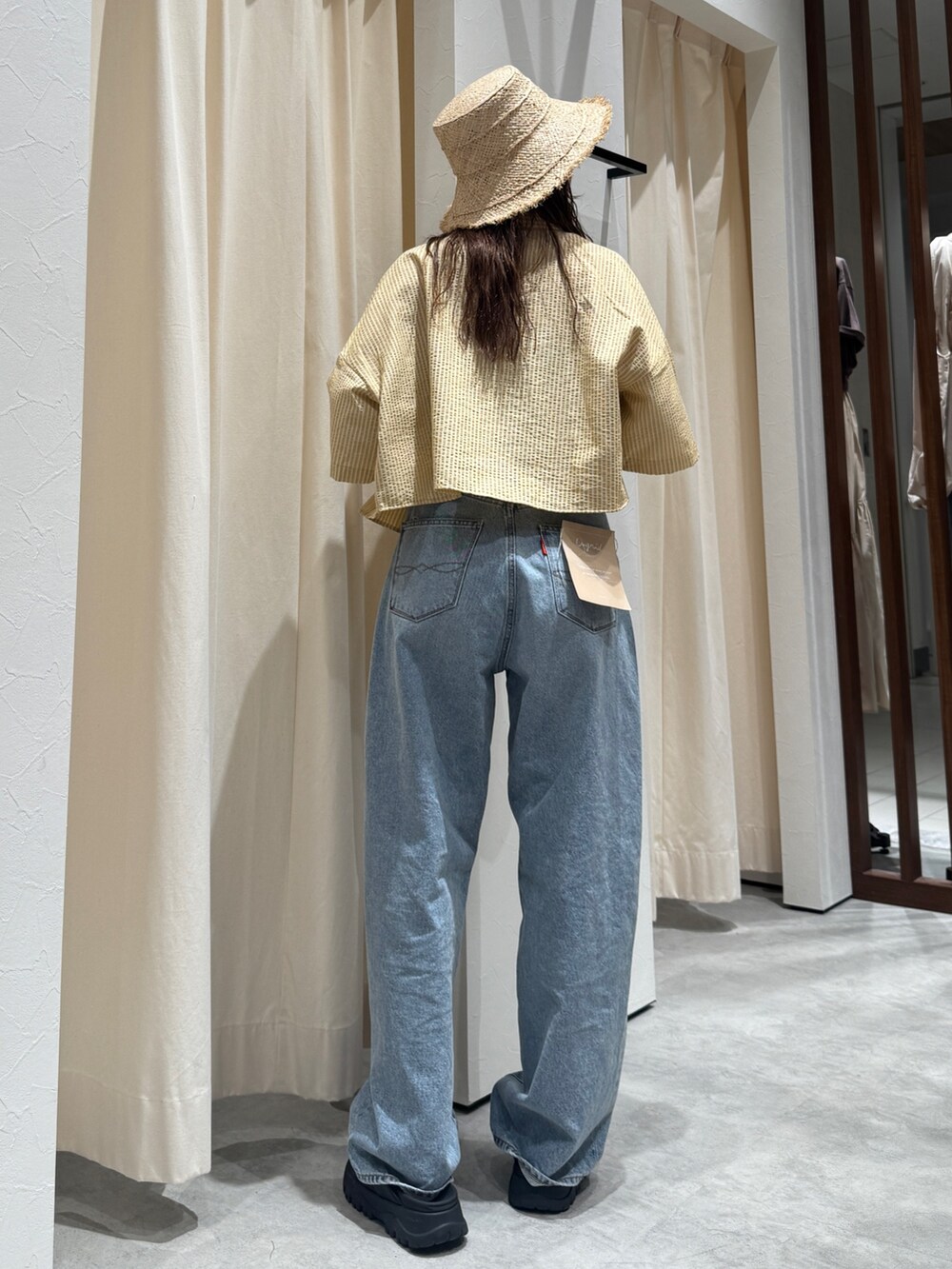 イエロー系のシャツ/ブラウス、ブルー系のデニムパンツ、ベージュ系のハットを着用したレディースの春コーディネートの3枚目の写真