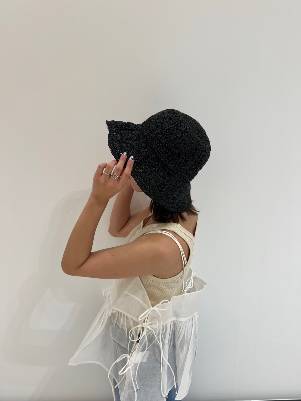 ホワイト系のシャツ/ブラウス、ベージュ系のタンクトップ、ブルー系のデニムパンツを着用したレディースの春コーディネートの7枚目の写真