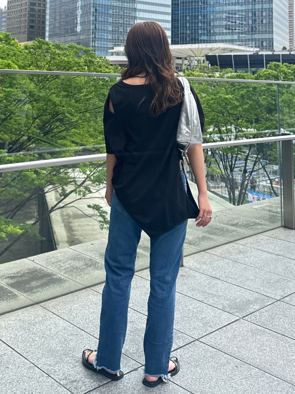 ブラック系のTシャツ/カットソー、ブルー系のデニムパンツを着用したレディースの春コーディネートの4枚目の写真