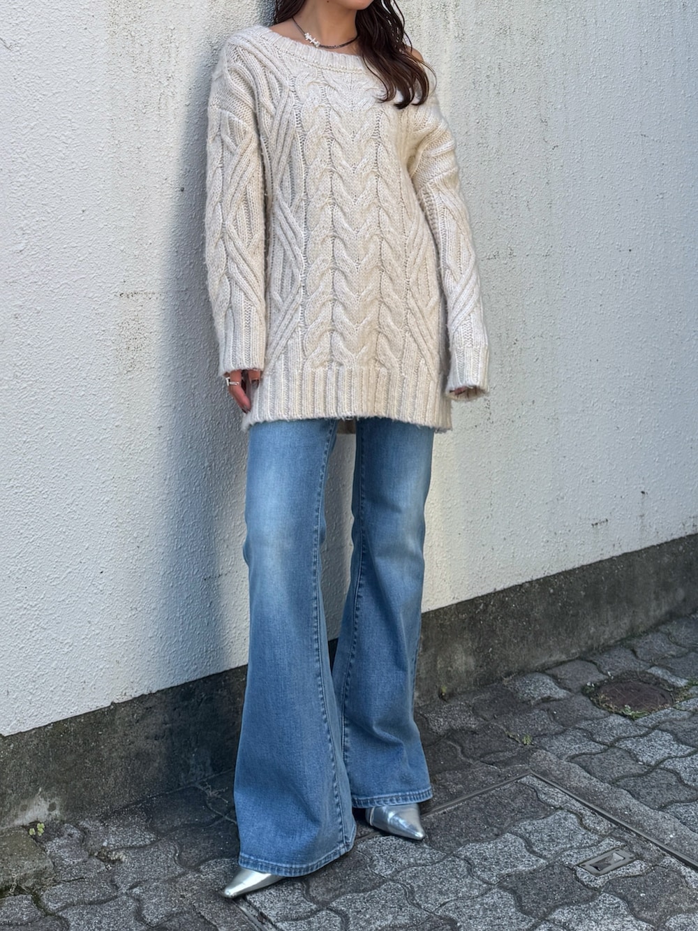 ホワイト系のニット/セーター、ブルー系のデニムパンツ、シルバー系のその他シューズを着用したレディースの夏コーディネートの7枚目の写真