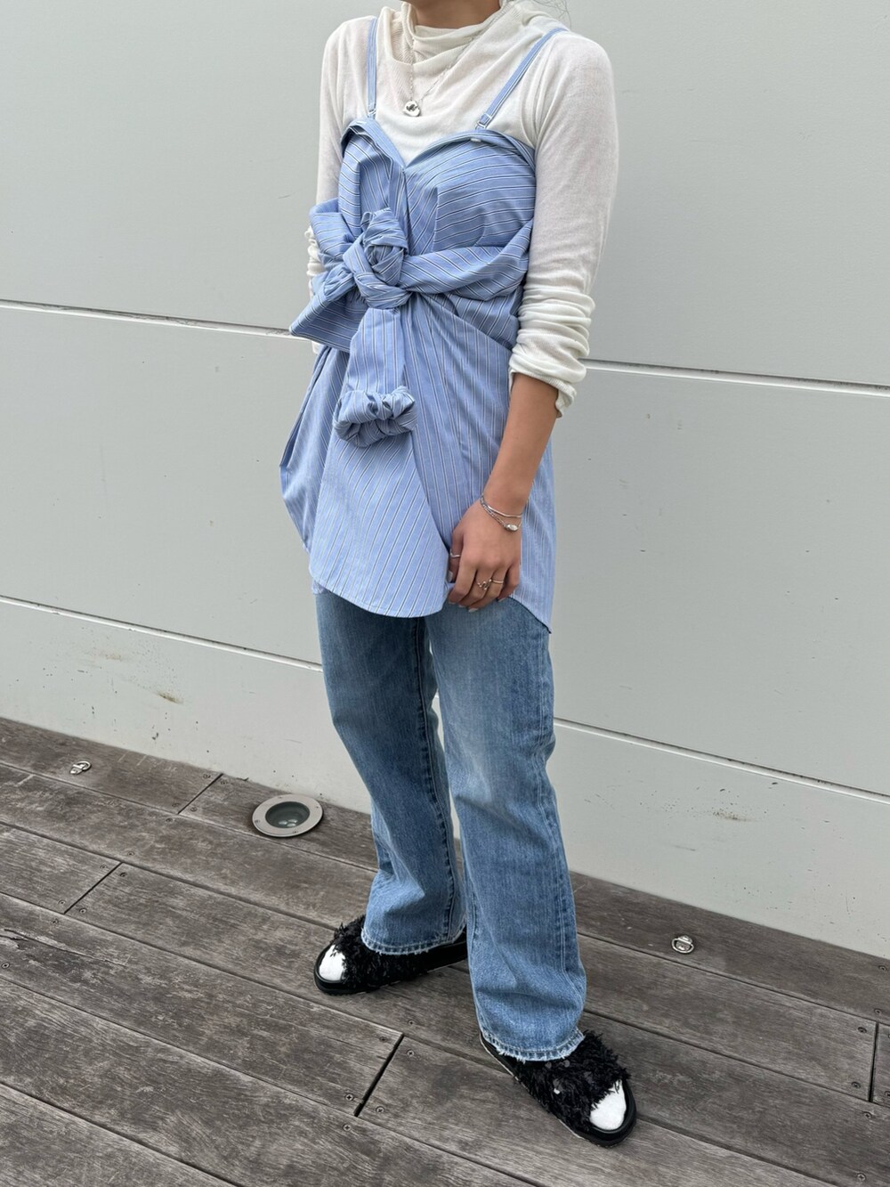 ホワイト系のTシャツ/カットソー、ブルー系のデニムパンツ、ブラック系のショルダーバッグを着用したレディースの冬コーディネートの9枚目の写真