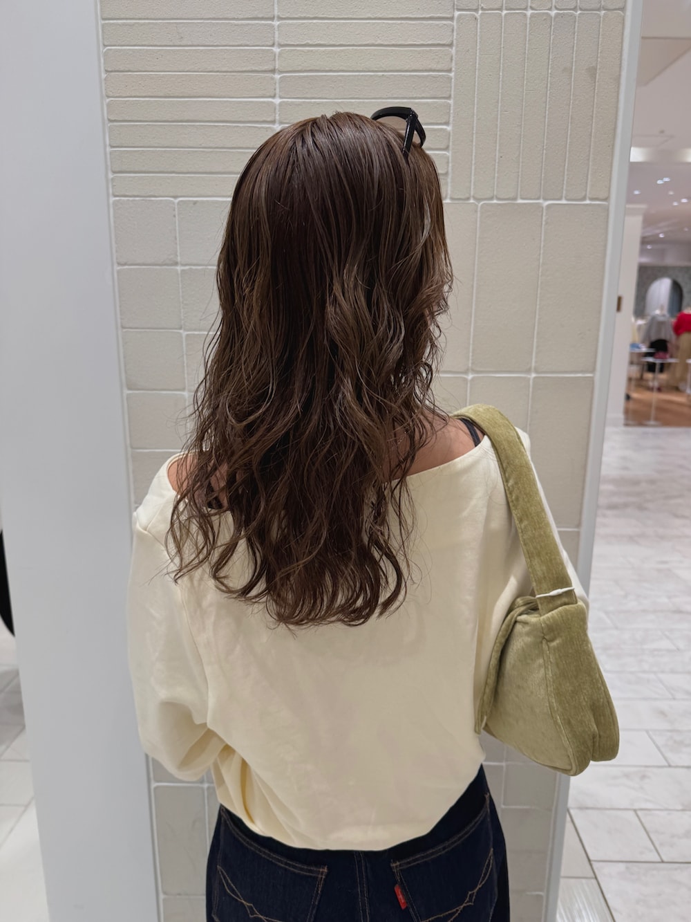 ブルー系のデニムパンツ、ホワイト系のTシャツ/カットソー、グリーン系のハンドバッグを着用したレディースの冬コーディネートの7枚目の写真