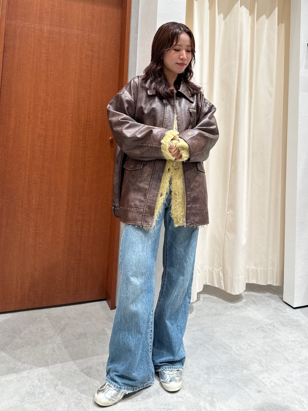 ブルー系のデニムパンツ、イエロー系のカーディガン/ボレロ、ブラウン系のブルゾンを着用したレディースの秋コーディネートの6枚目の写真