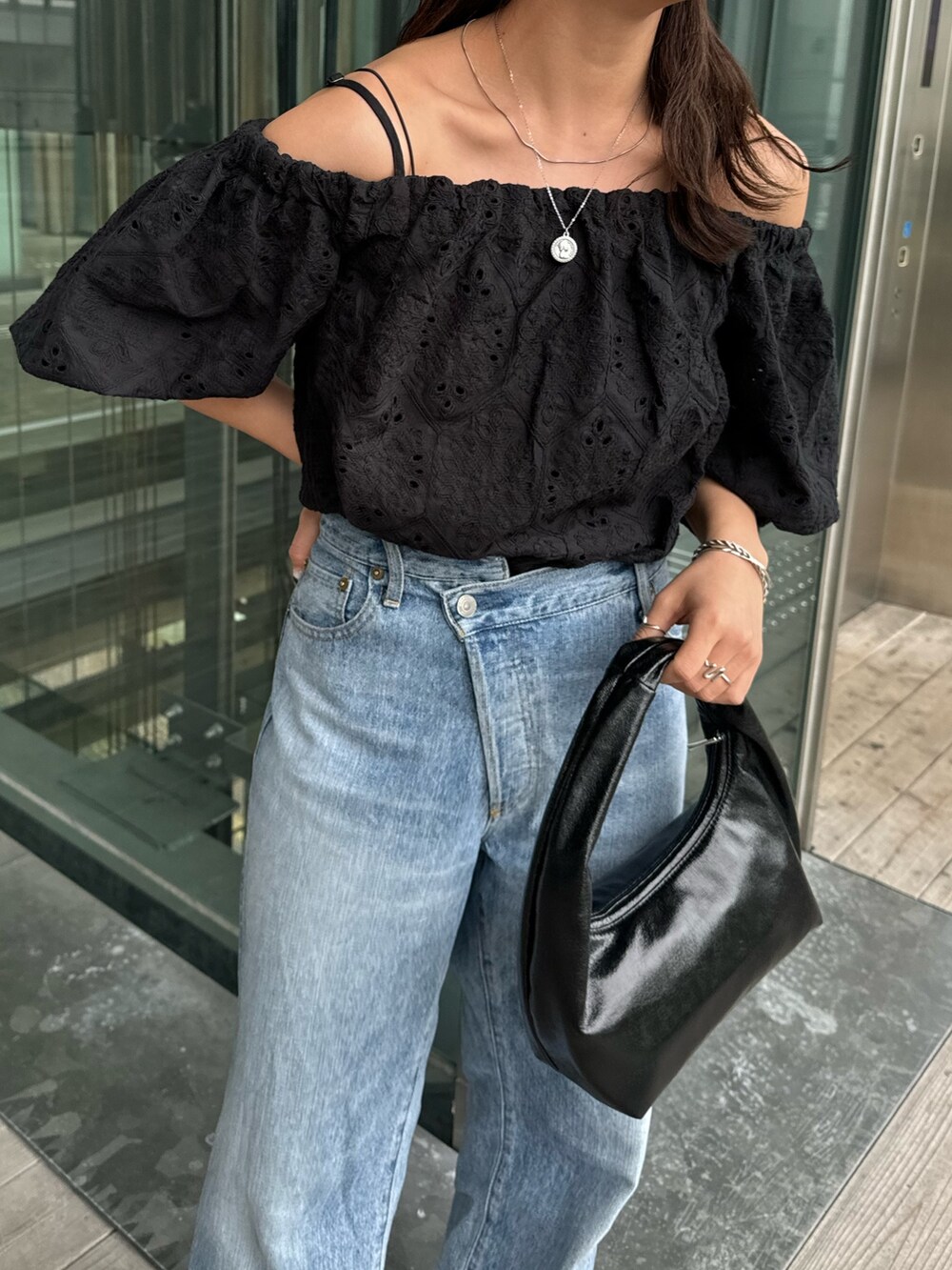 ブルー系のデニムパンツ、ブラック系のシャツ/ブラウス、ブラック系のハンドバッグを着用したレディースの春コーディネートの7枚目の写真