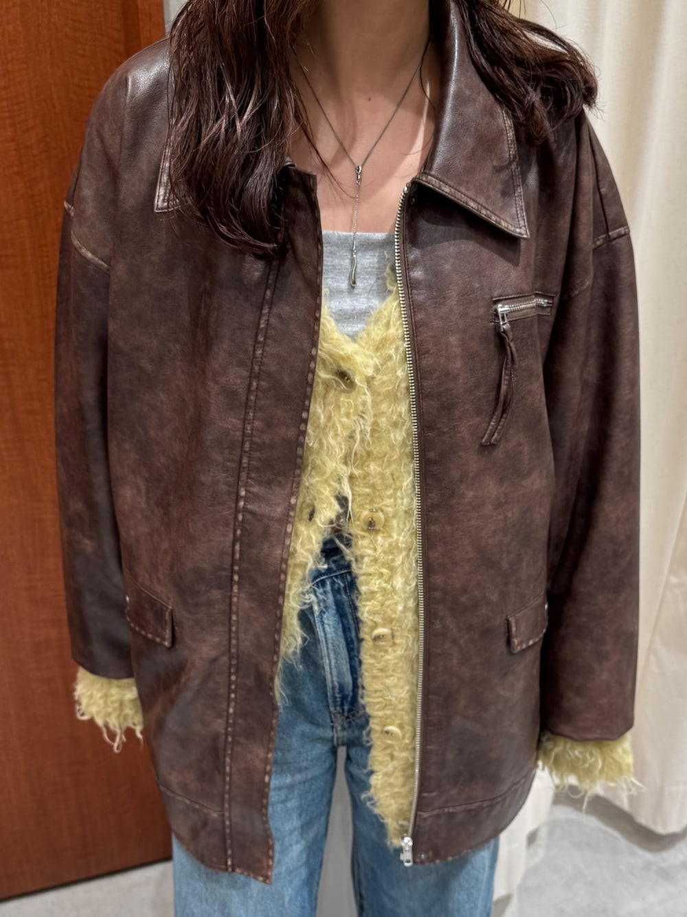 ブルー系のデニムパンツ、イエロー系のカーディガン/ボレロ、ブラウン系のブルゾンを着用したレディースの秋コーディネートの9枚目の写真