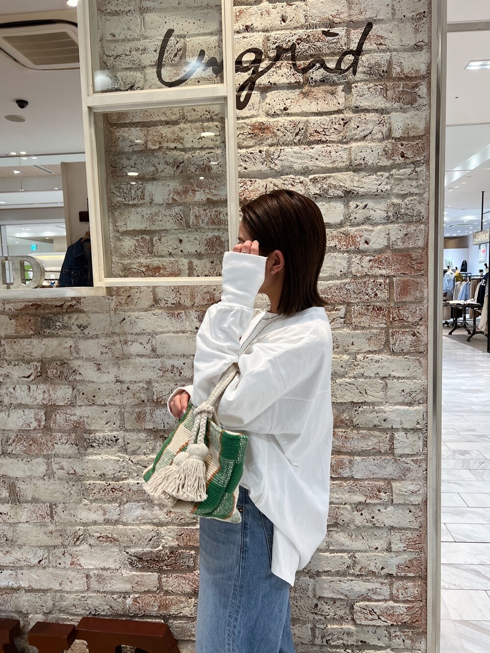 ブルー系のデニムパンツ、グリーン系のスニーカーを着用したレディースの春コーディネートの5枚目の写真