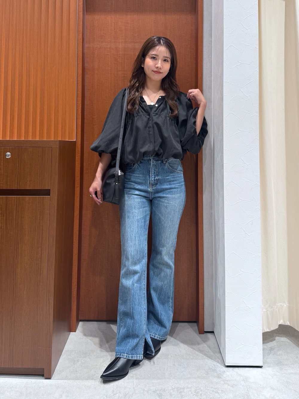 ブルー系のデニムパンツ、ブラウン系のシャツ/ブラウス、ブラック系のハンドバッグを着用したレディースの夏コーディネートの6枚目の写真