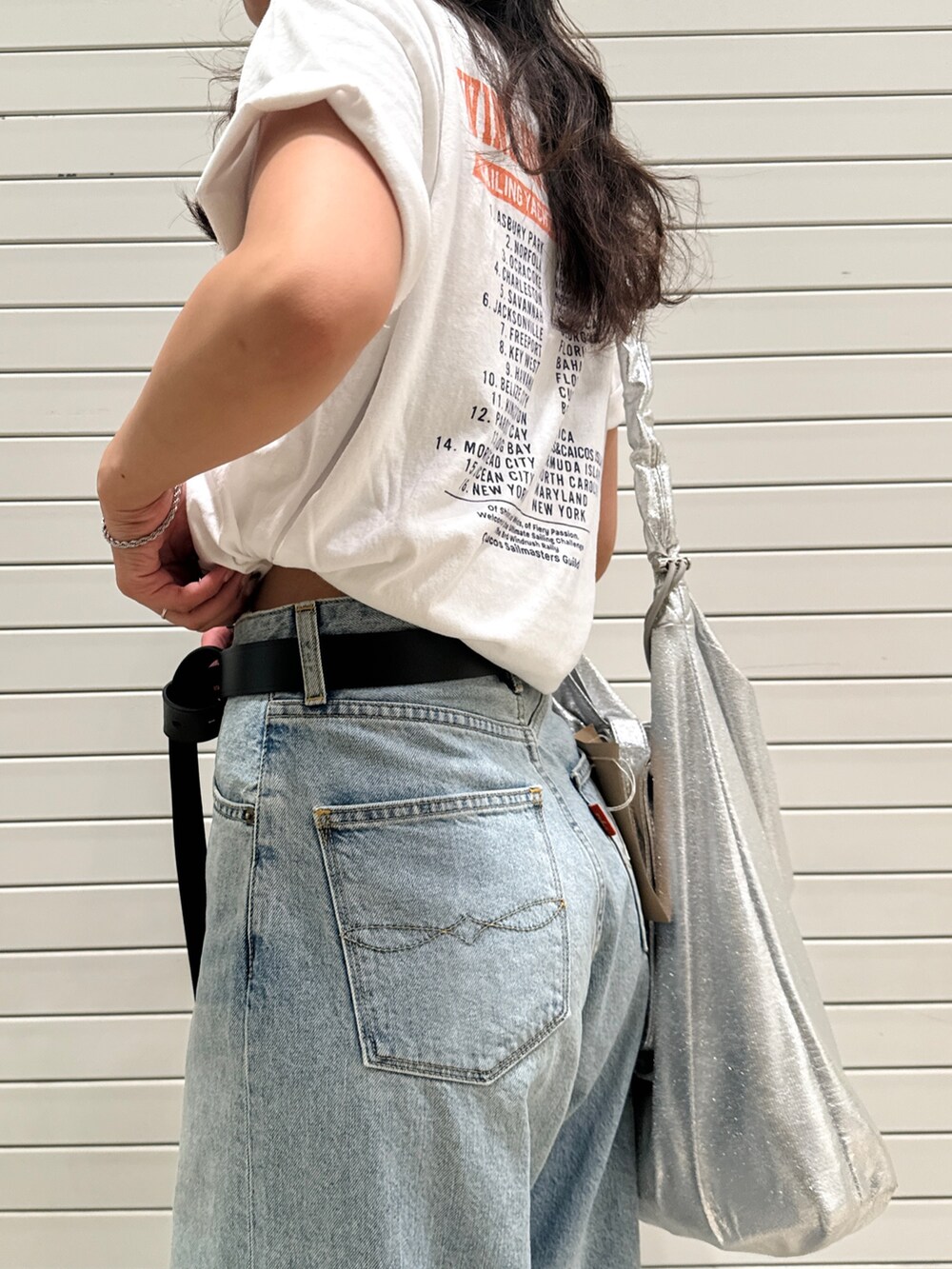ブルー系のデニムパンツ、ホワイト系のTシャツ/カットソー、ブラック系のベルトを着用したレディースの夏コーディネートの8枚目の写真