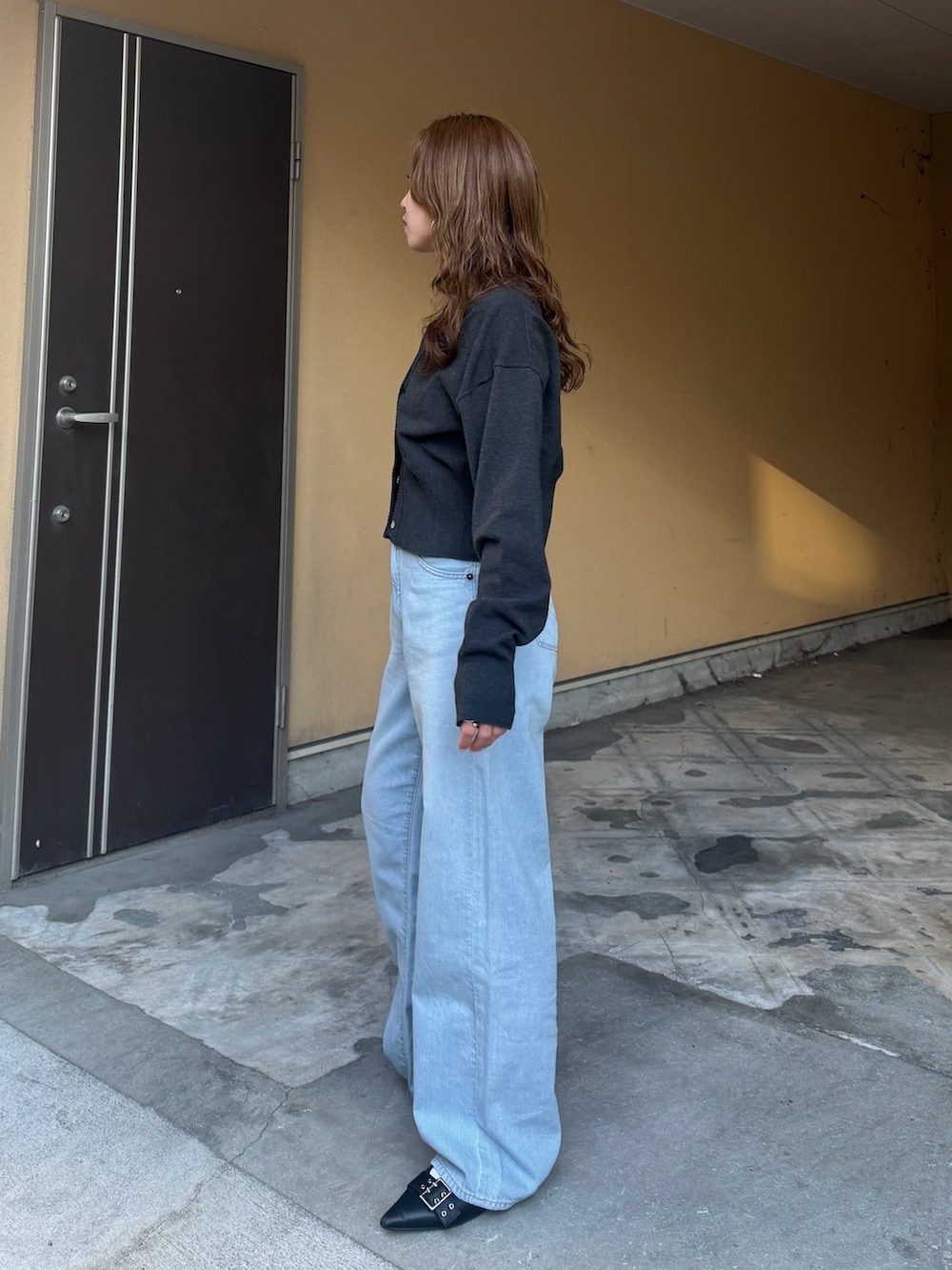 グレー系のカーディガン/ボレロ、ブルー系のデニムパンツを着用したレディースの春コーディネートの6枚目の写真