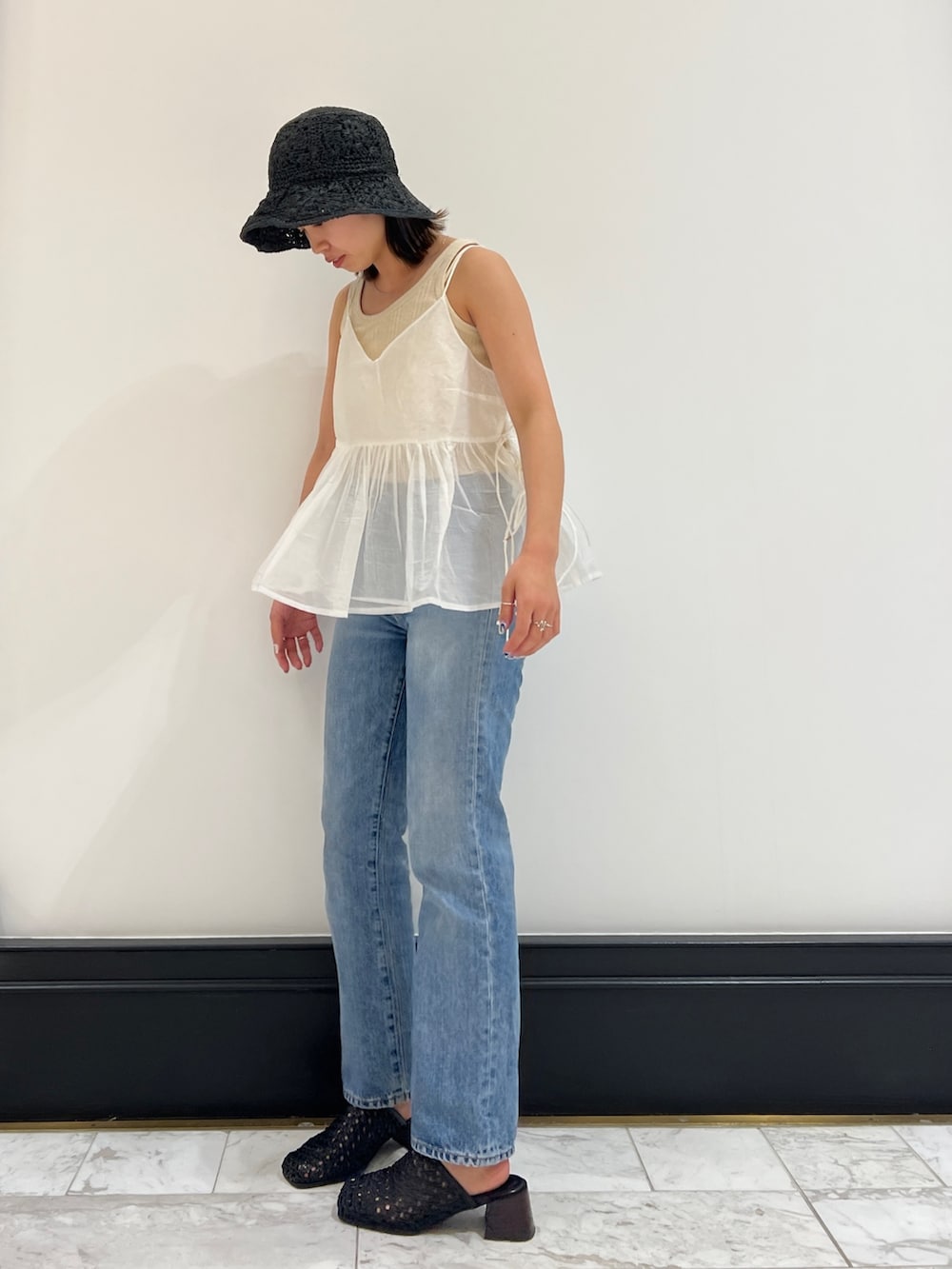 ホワイト系のシャツ/ブラウス、ベージュ系のタンクトップ、ブルー系のデニムパンツを着用したレディースの春コーディネートの3枚目の写真