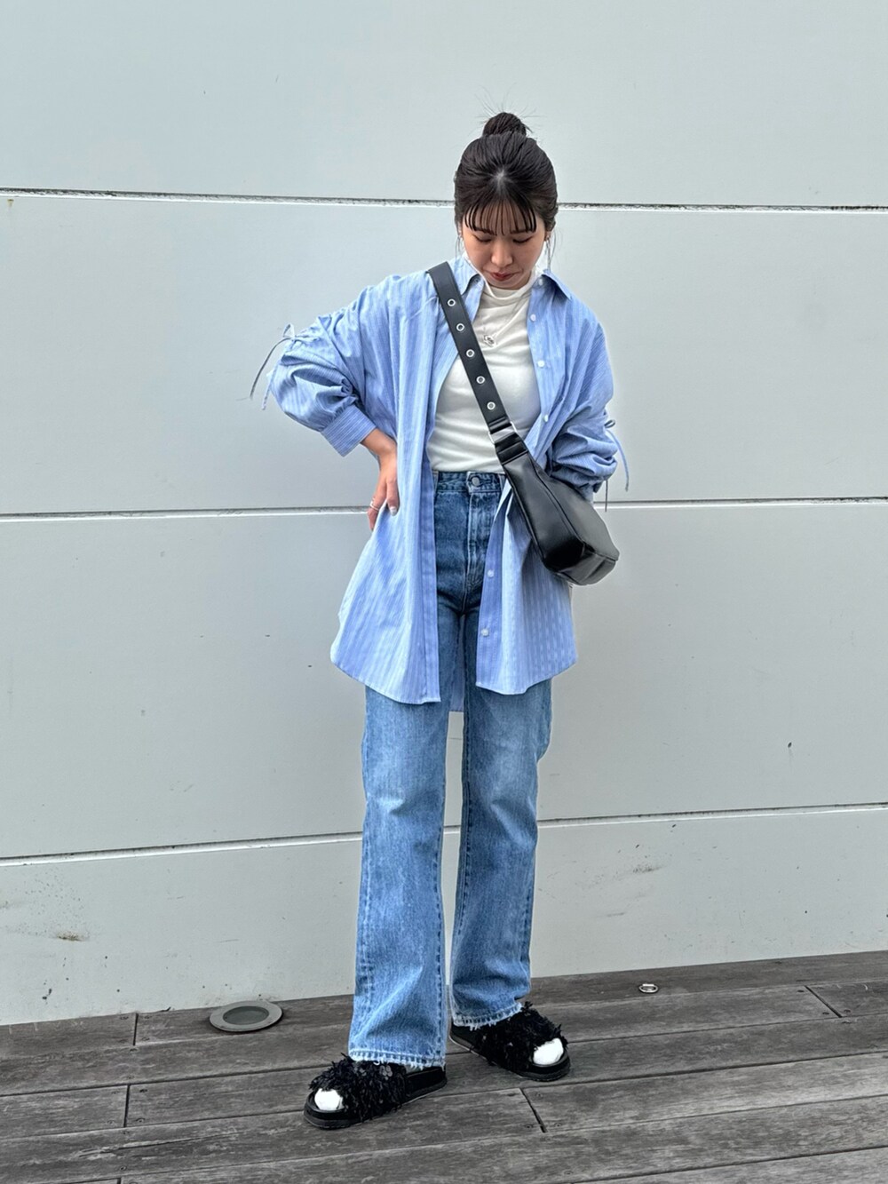 ホワイト系のTシャツ/カットソー、ブルー系のデニムパンツ、ブラック系のショルダーバッグを着用したレディースの冬コーディネートの4枚目の写真