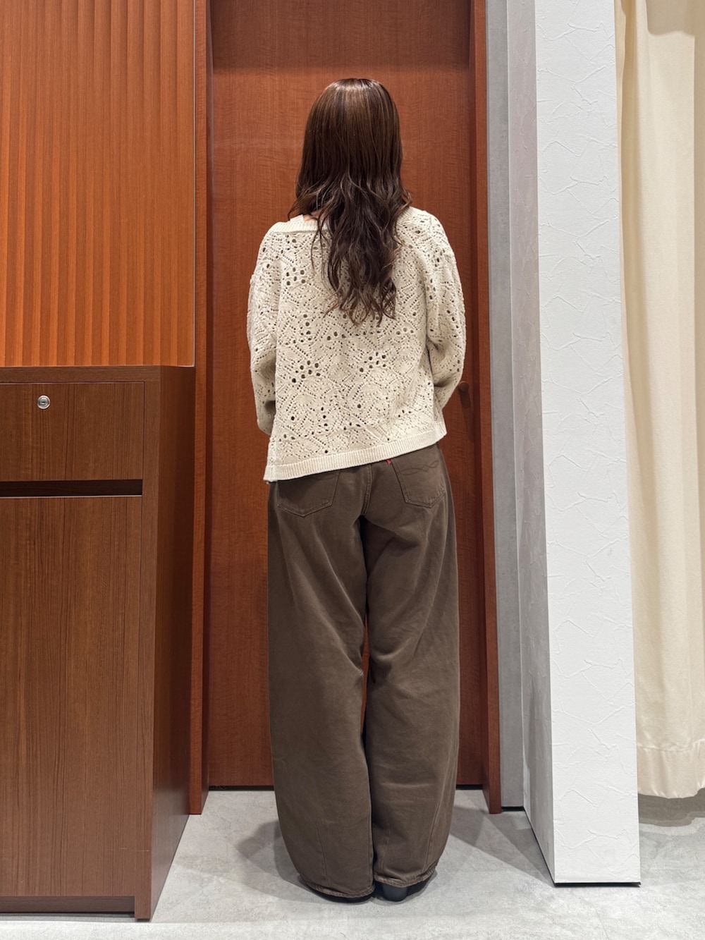 ブラウン系のデニムパンツ、ホワイト系のアンサンブル、ブラック系のその他シューズを着用したレディースの秋コーディネートの9枚目の写真