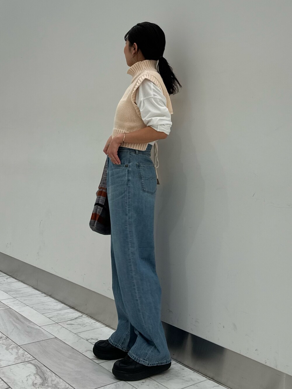 ホワイト系のワンピース、ホワイト系のTシャツ/カットソー、グレー系のハンドバッグを着用したレディースの冬コーディネートの5枚目の写真