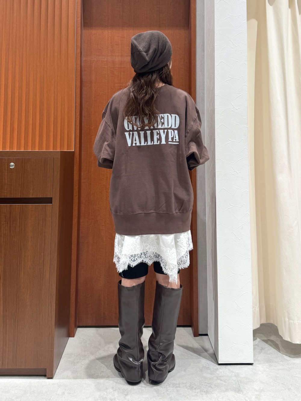 ブラウン系のスウェット、ホワイト系のワンピース、ブラック系のその他パンツを着用したレディースの秋コーディネートの4枚目の写真