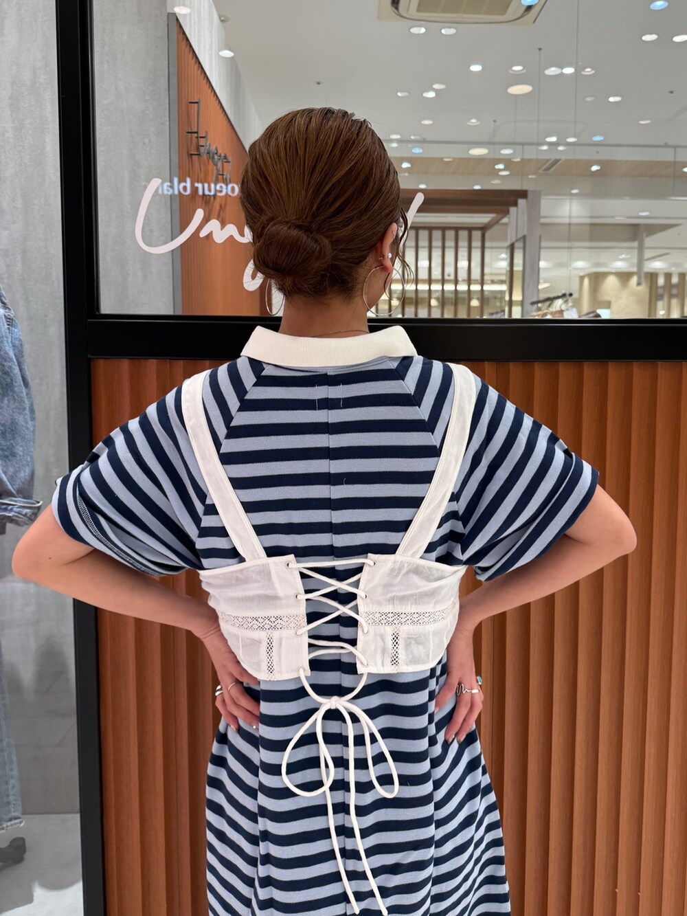 ホワイト系のキャミソール、ブルー系のワンピース、ブラック系のスニーカーを着用したレディースの春コーディネートの9枚目の写真