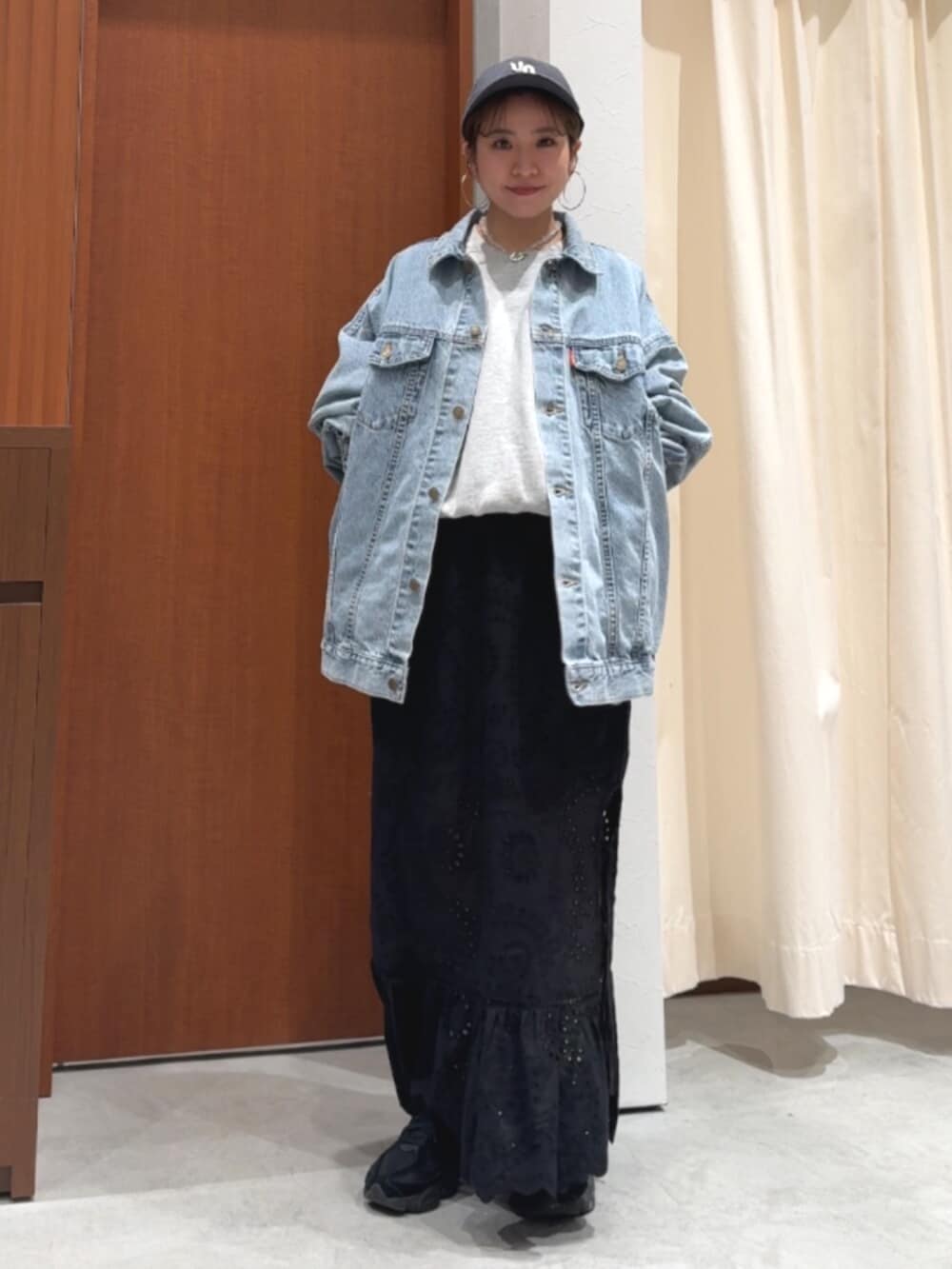 ブラック系のスカート、ブルー系のデニムジャケット、グレー系のスウェットを着用したレディースの春コーディネートの2枚目の写真