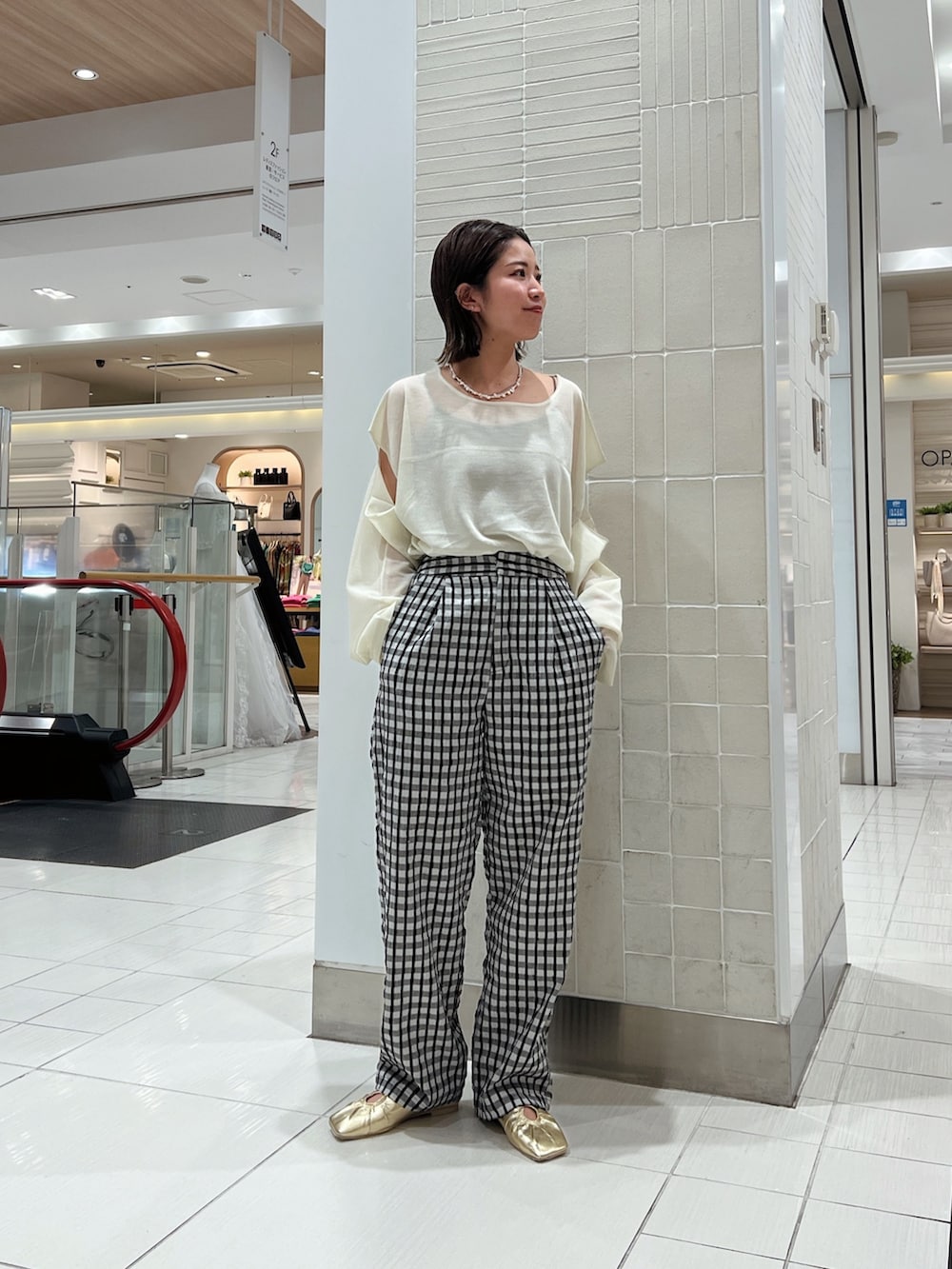 イエロー系のニット/セーター、イエロー系のパンプス、グレー系のその他パンツを着用したレディースの冬コーディネートの3枚目の写真