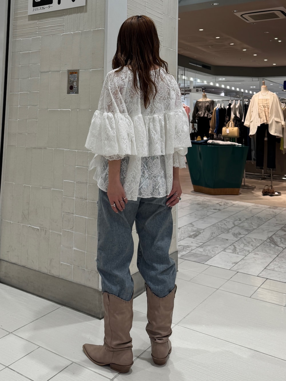 ブルー系のデニムパンツ、ホワイト系のシャツ/ブラウス、ベージュ系のブーツを着用したレディースの春コーディネートの3枚目の写真