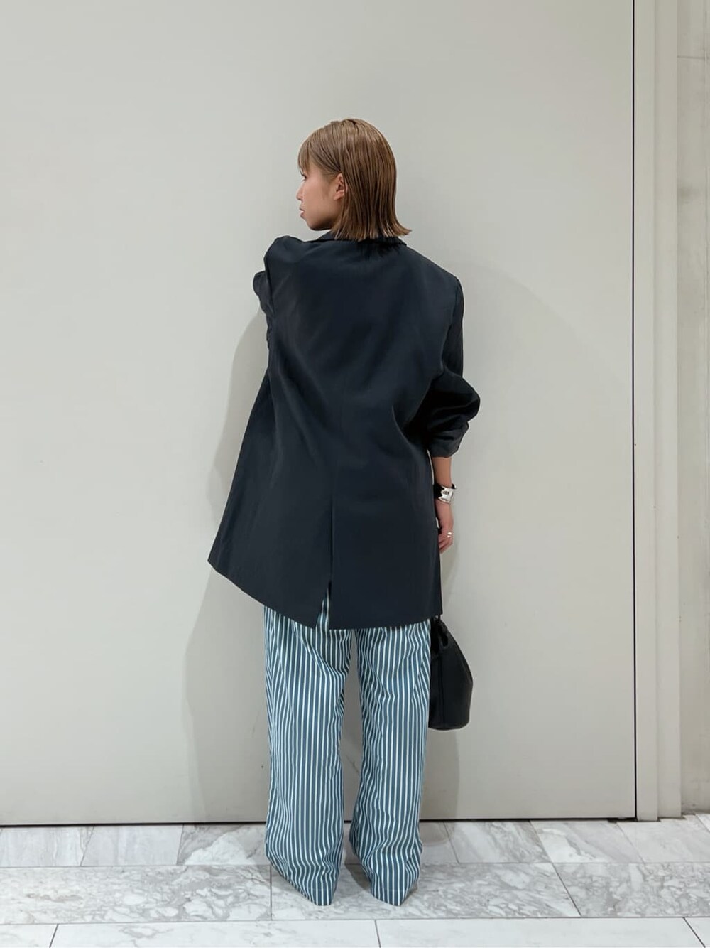 グリーン系のその他パンツ、ブラック系のハンドバッグ、グレー系のテーラードジャケットを着用したレディースの夏コーディネートの5枚目の写真