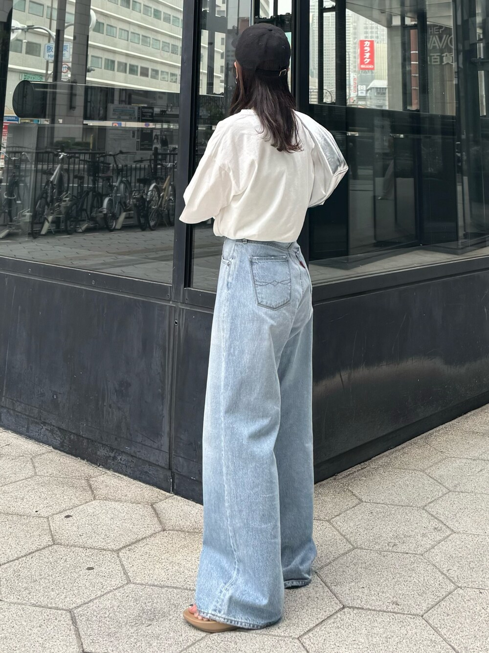ブルー系のデニムパンツ、ホワイト系のTシャツ/カットソー、シルバー系のハンドバッグを着用したレディースの春コーディネートの5枚目の写真