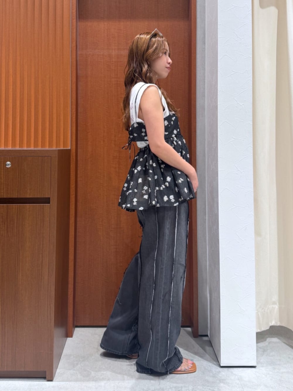 ブラック系のデニムパンツ、ブラック系のキャミソール、ホワイト系のタンクトップを着用したレディースの夏コーディネートの2枚目の写真
