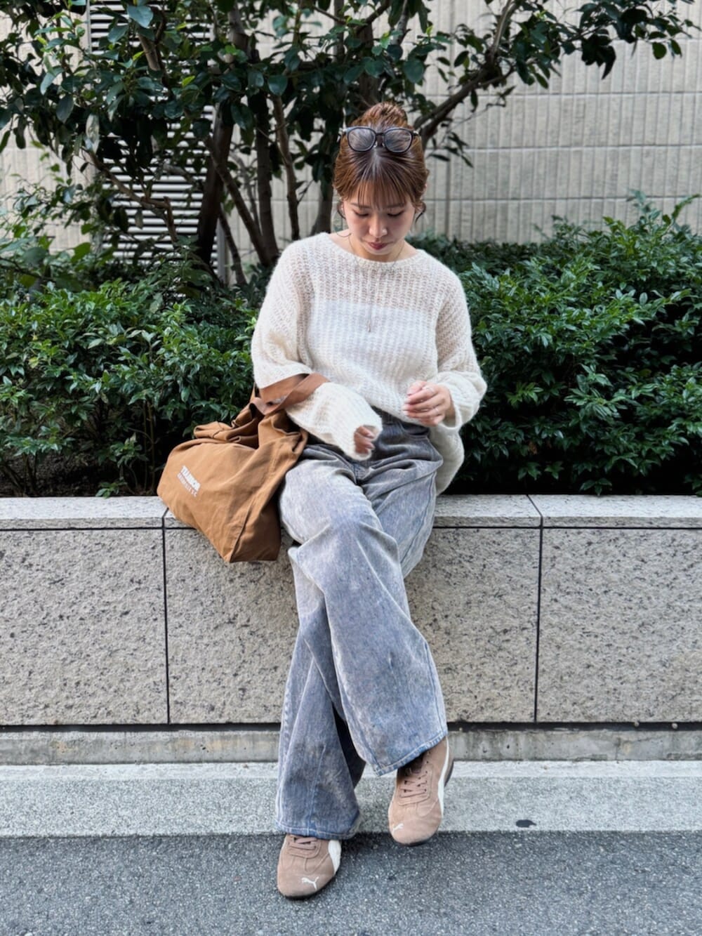 ベージュ系のデニムパンツ、ホワイト系のニット/セーター、ブラウン系のトートバッグを着用したレディースの夏コーディネートの7枚目の写真