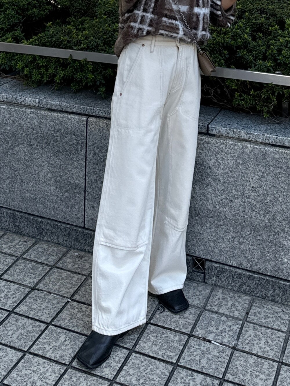 ブラウン系のニット/セーター、ホワイト系のデニムパンツを着用したレディースの秋コーディネートの6枚目の写真