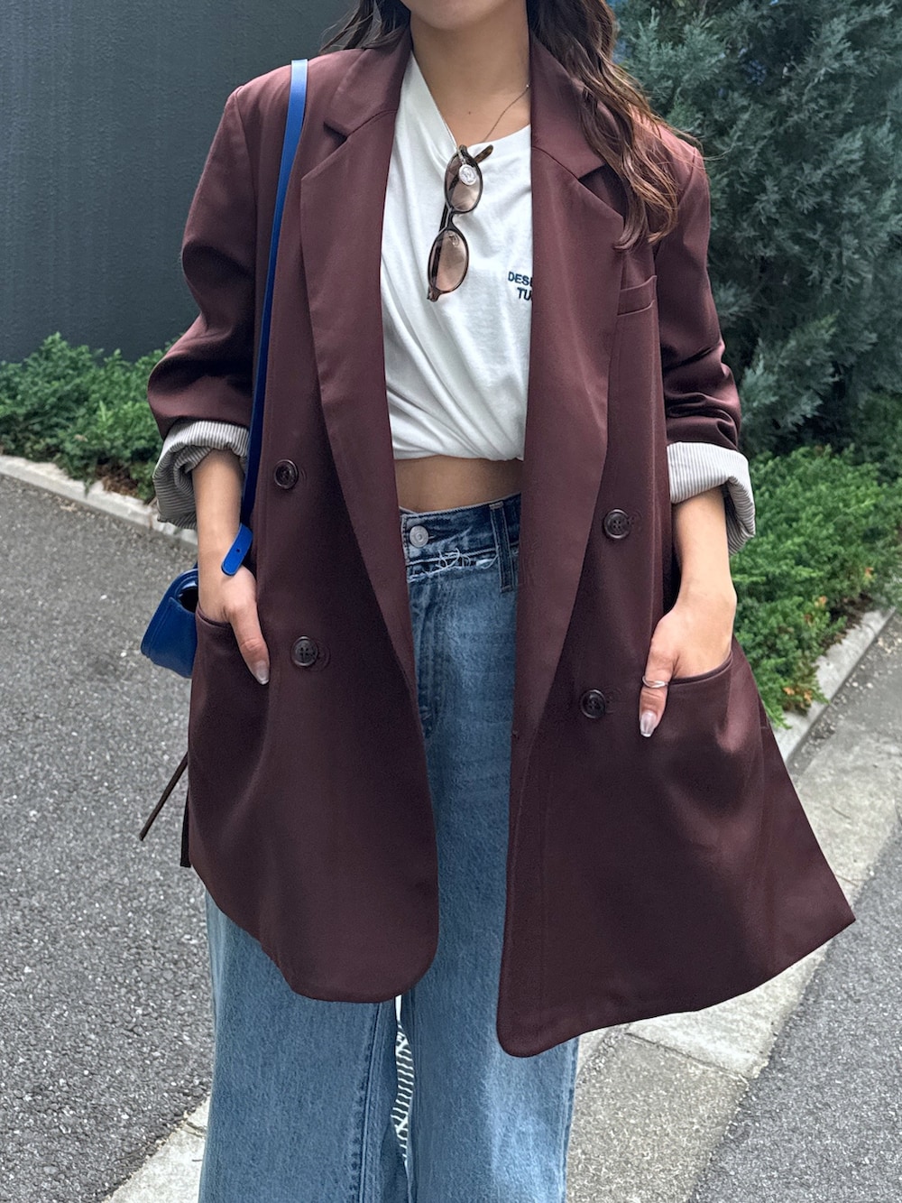 ブルー系のデニムパンツ、ブラウン系のテーラードジャケット、ホワイト系のTシャツ/カットソーを着用したレディースの夏コーディネートの6枚目の写真